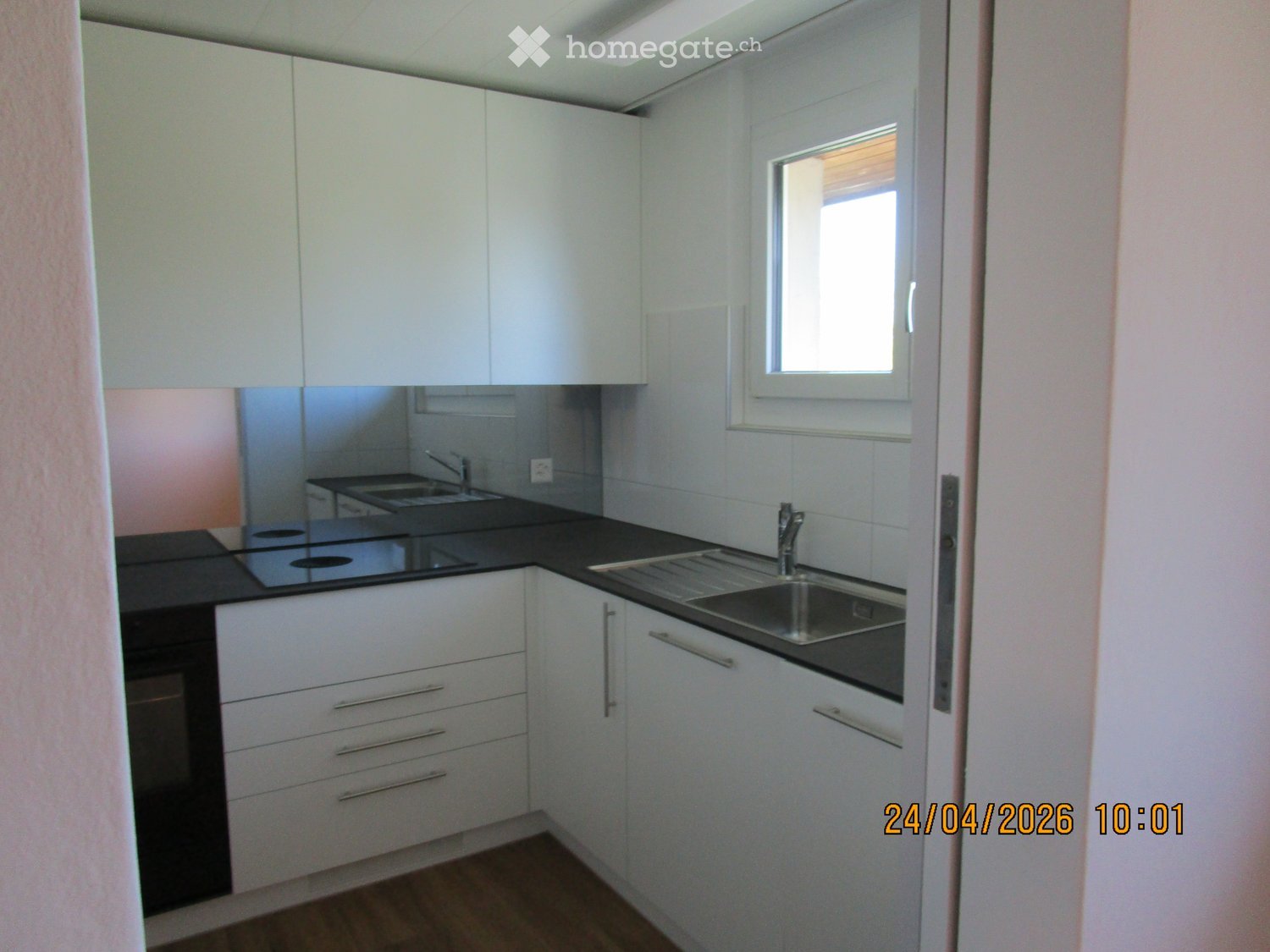 Kitchen. Modern kitchen with white cabinets, black countertops, a sink, and a stove.