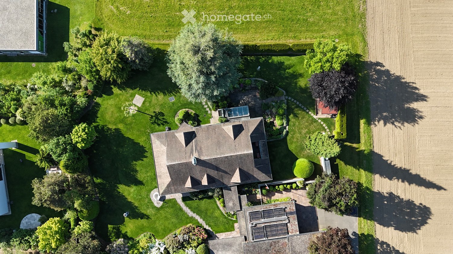 House with a swimming pool, solar panels, garden, and trees