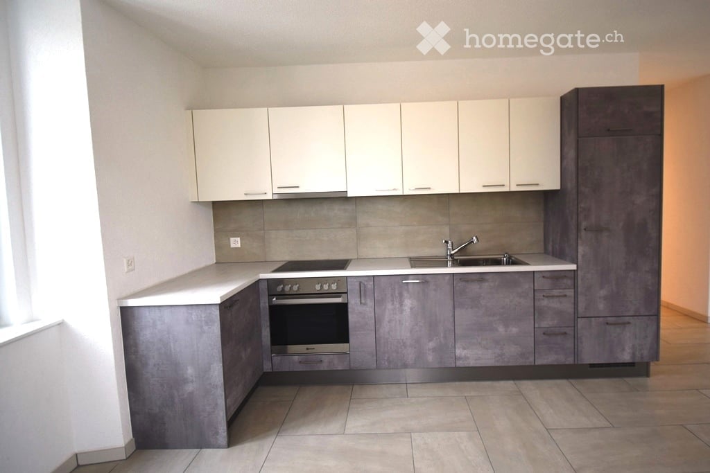 modern kitchen with white and gray cabinets, tiled floor, gas stove, oven, sink, faucet, power outlet