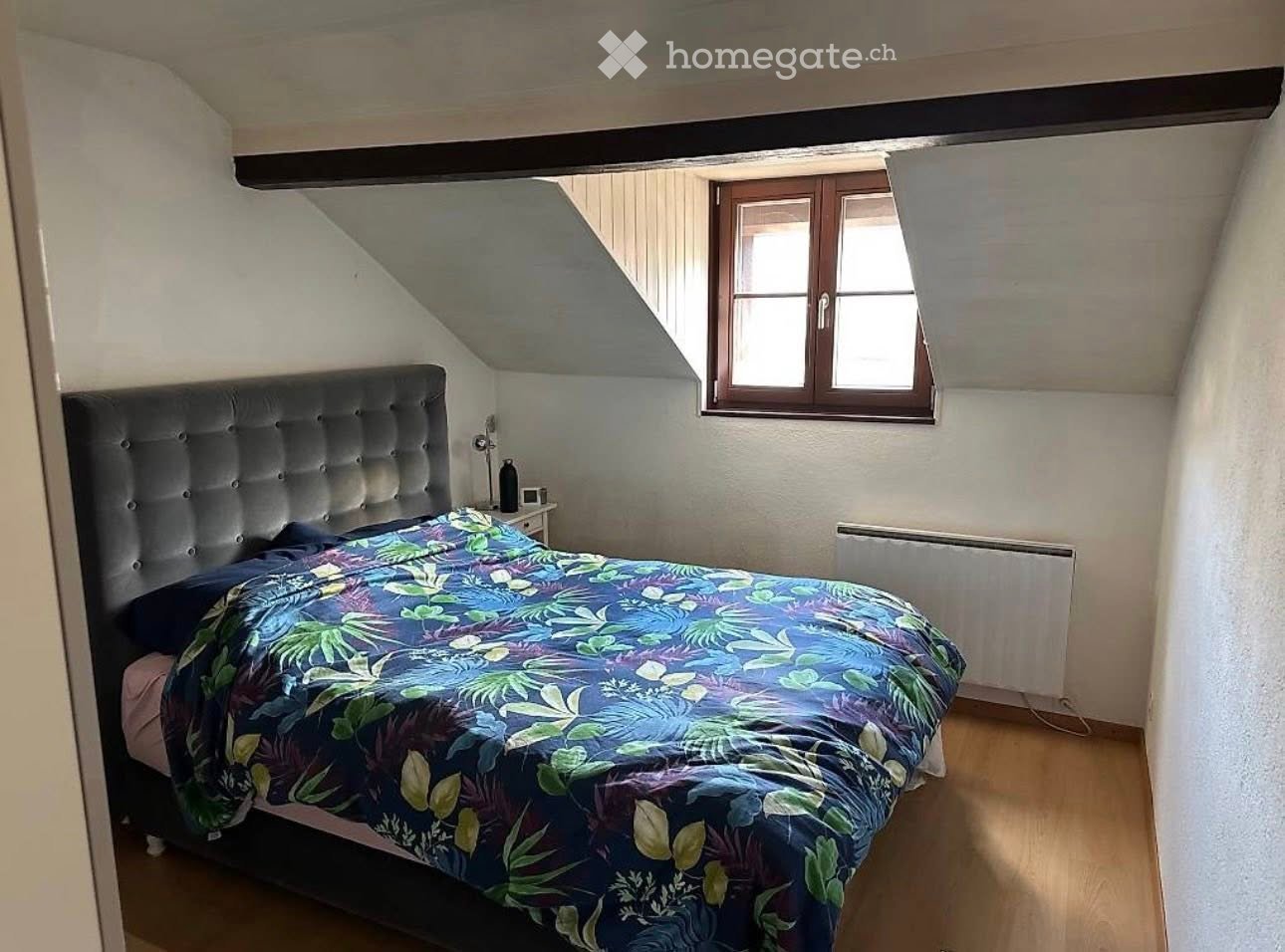 bedroom with bed, nightstand, lamp, radiator, window, wooden floor