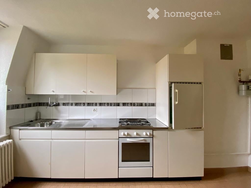 modern kitchen with white cabinets, stainless steel countertop, gas stove, oven, sink, refrigerator, dishwasher, and a radiator