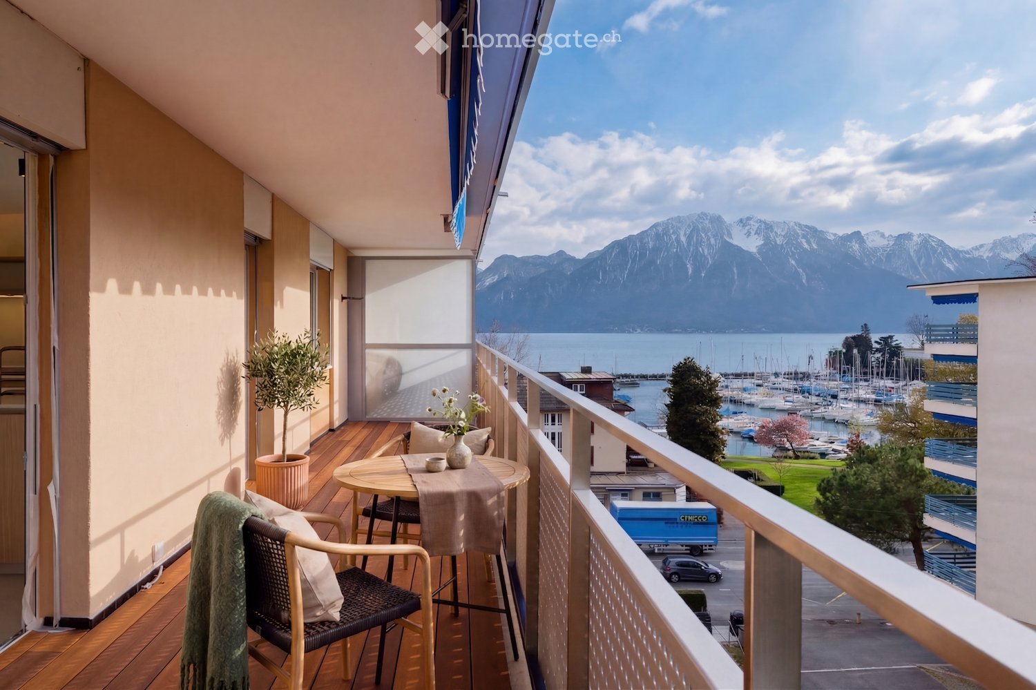 wooden floor, table with chairs, potted plant, railing, view of mountains and lake