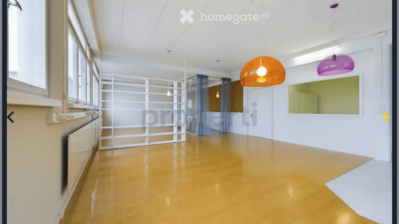 Empty room with wooden floor, white walls, large windows, white shelves, orange and pink lamps