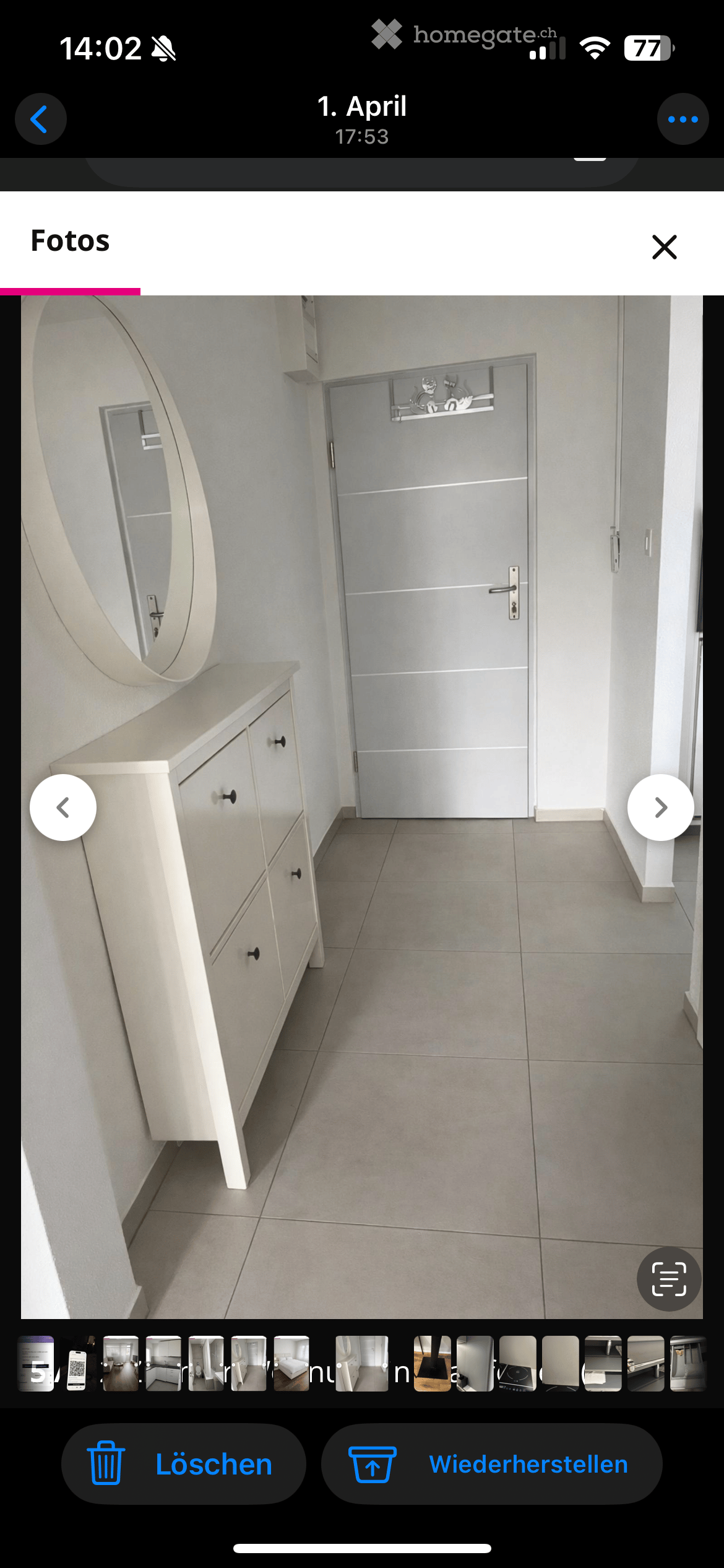 Entrance hall with a white cabinet, mirror, and tiled floor.