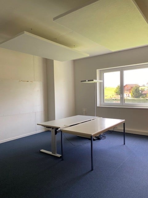 empty room, two desks, large window, white walls, blue carpet