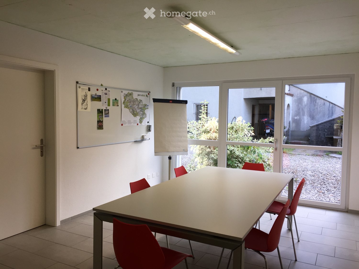 empty room, white walls, white floor, whiteboard, projector, table, red chairs, glass doors