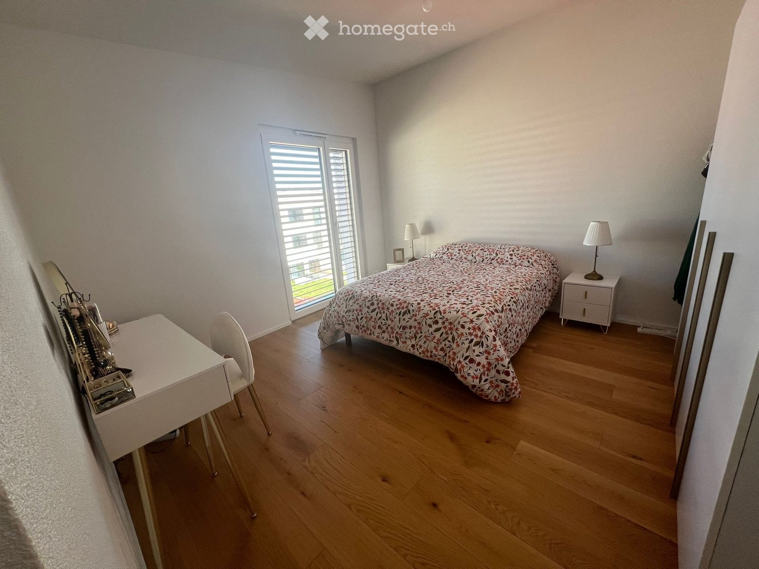 Bedroom with bed, nightstands, lamps, desk, chair, and window with blinds