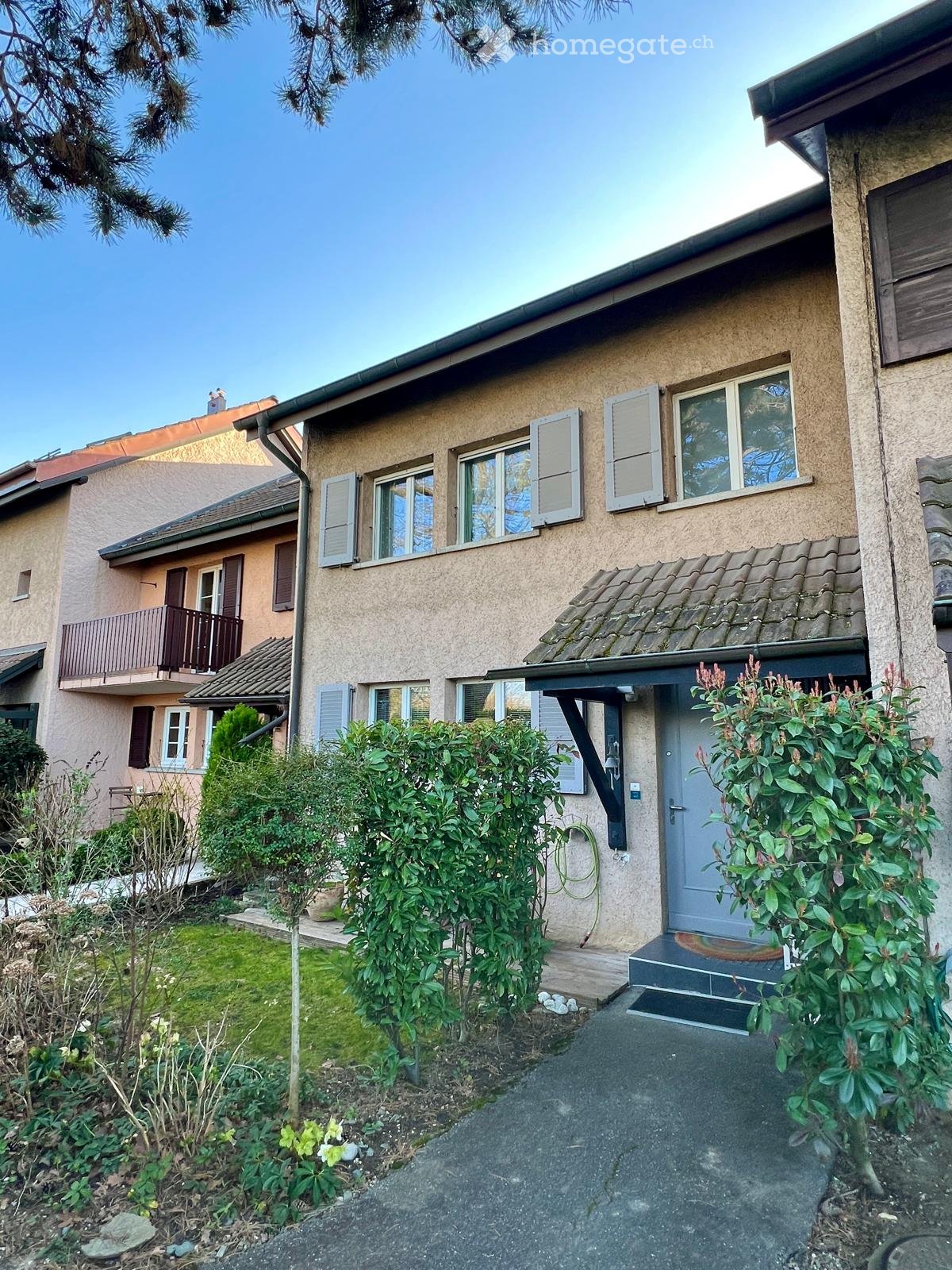 2 story house, beige walls, white windows, brown roof, balcony, driveway, garden