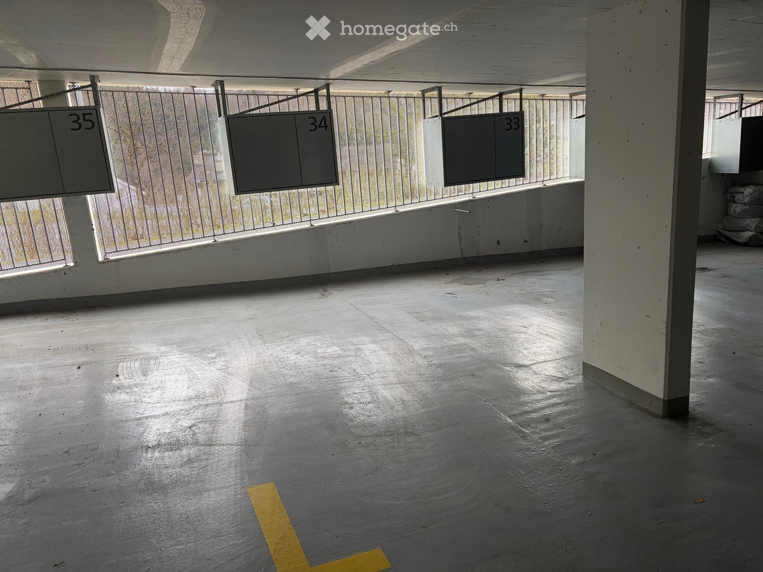 underground parking lot, numbered parking spaces, metal railings, concrete floor, yellow parking line