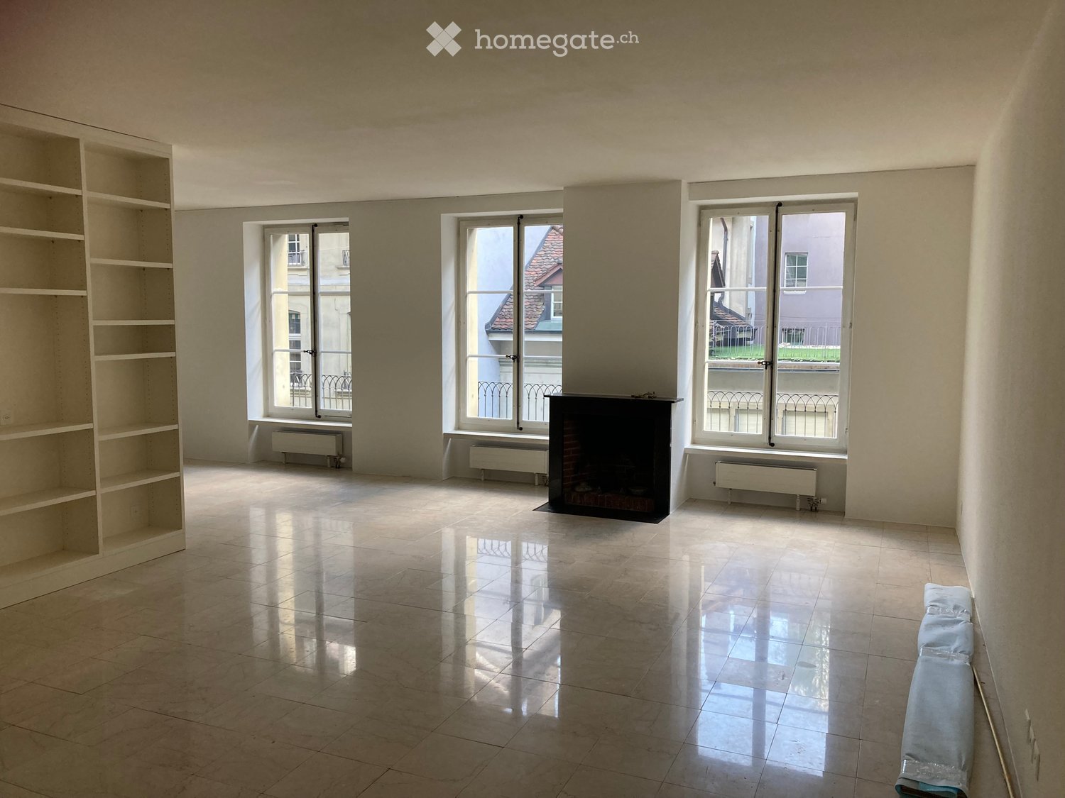 empty room, fireplace, large windows, tiled floor, white shelves