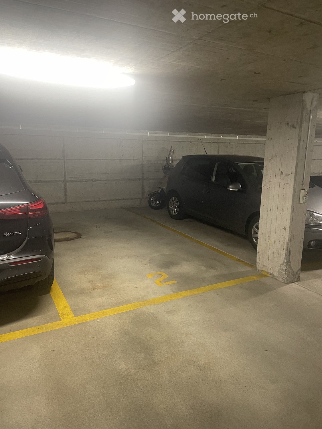 {"visible_features": [], "type": "Garage", "objects": ["car", "motorcycle"], "description": "An underground parking space with two cars parked, one of which is a motorcycle. The space has yellow markings on the floor.", "localized_descriptions": {"EN": "A