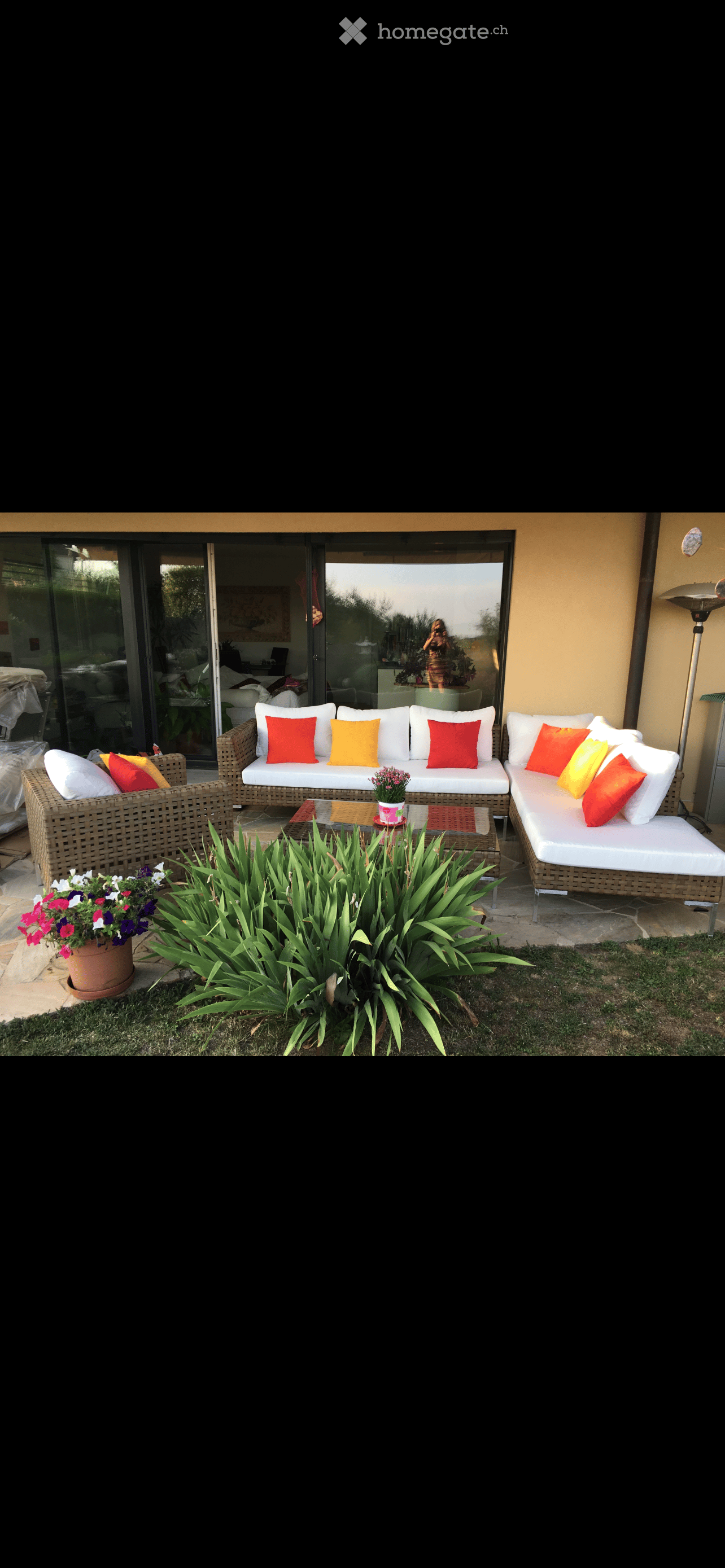 Outdoor seating area with wicker couches, glass doors, and a view of the outside