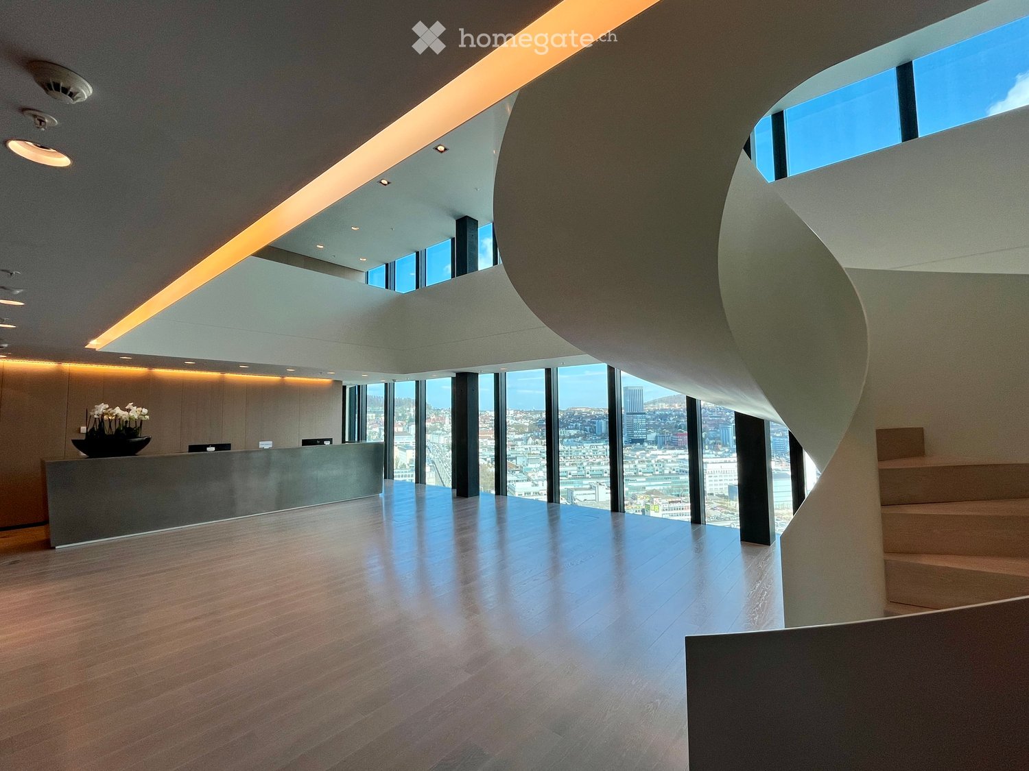 modern design, wooden floor, large windows, spiral staircase, reception desk, flowers