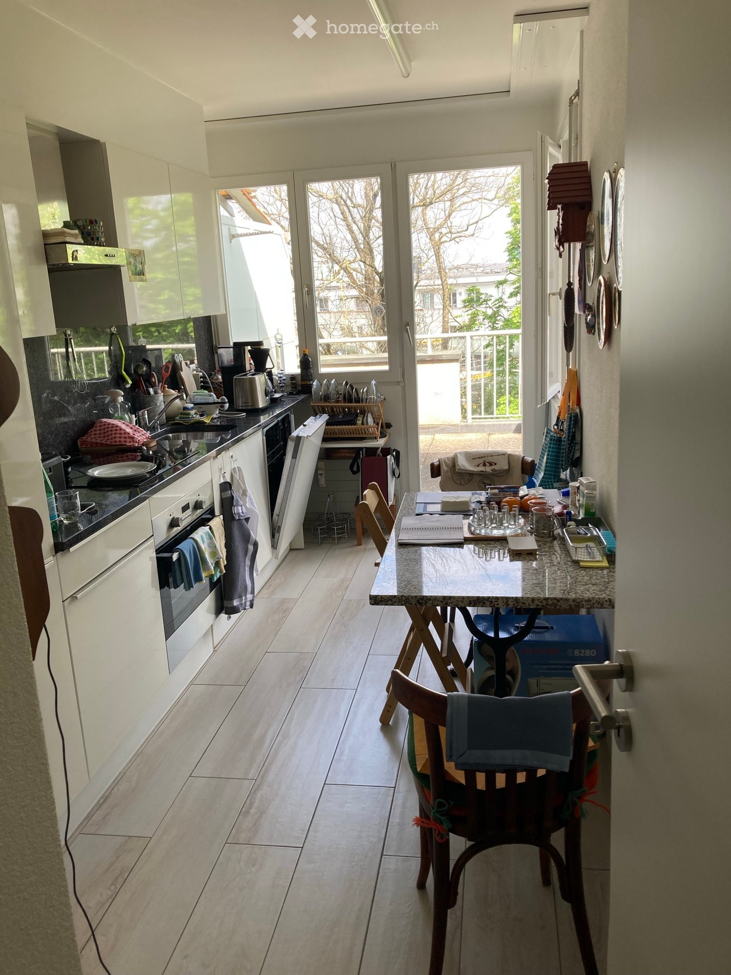 kitchen with dining area, balcony, wooden floor, white cabinets, granite countertop, open to living room
