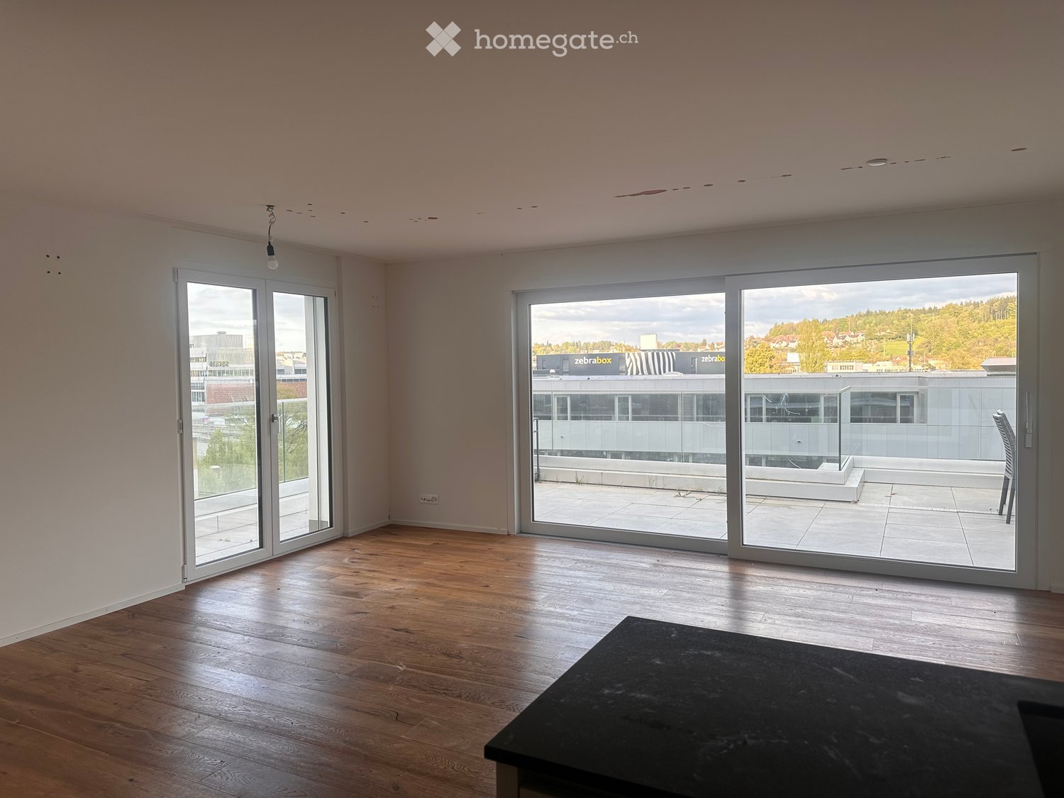 empty room, wooden floor, white walls, sliding glass doors, balcony, city view