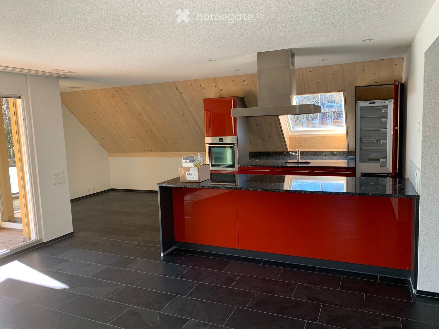 modern kitchen with red cabinets, black countertops, wooden ceiling, stainless steel appliances, glass door, window