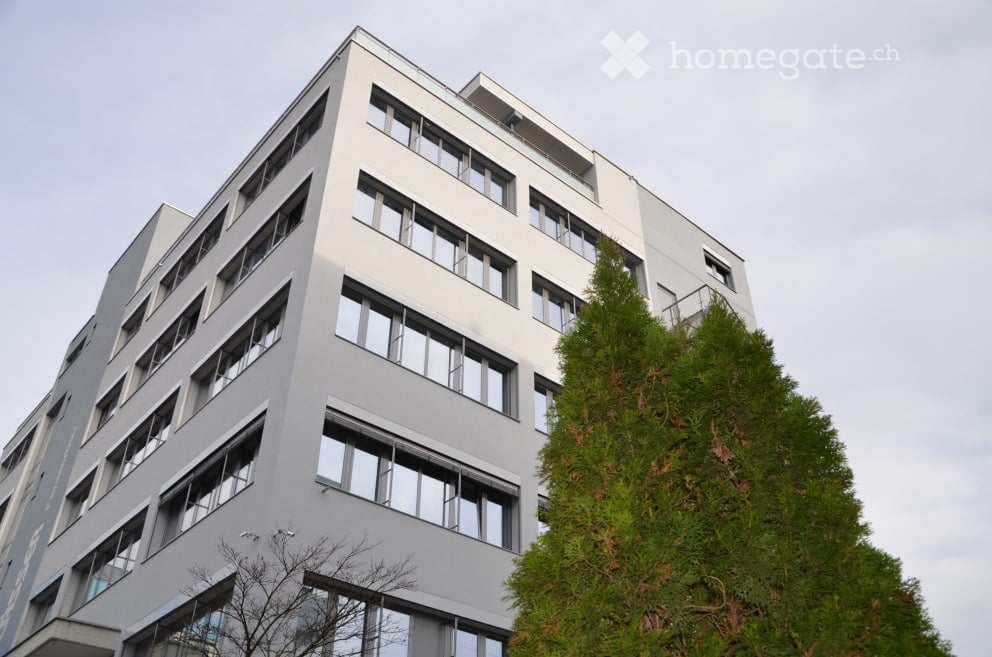 modern office building, white exterior, large windows, multiple floors, glass railings, greenery
