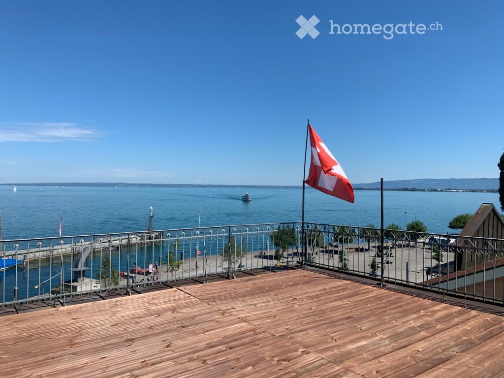 wooden deck, metal railing, flag, view of the sea