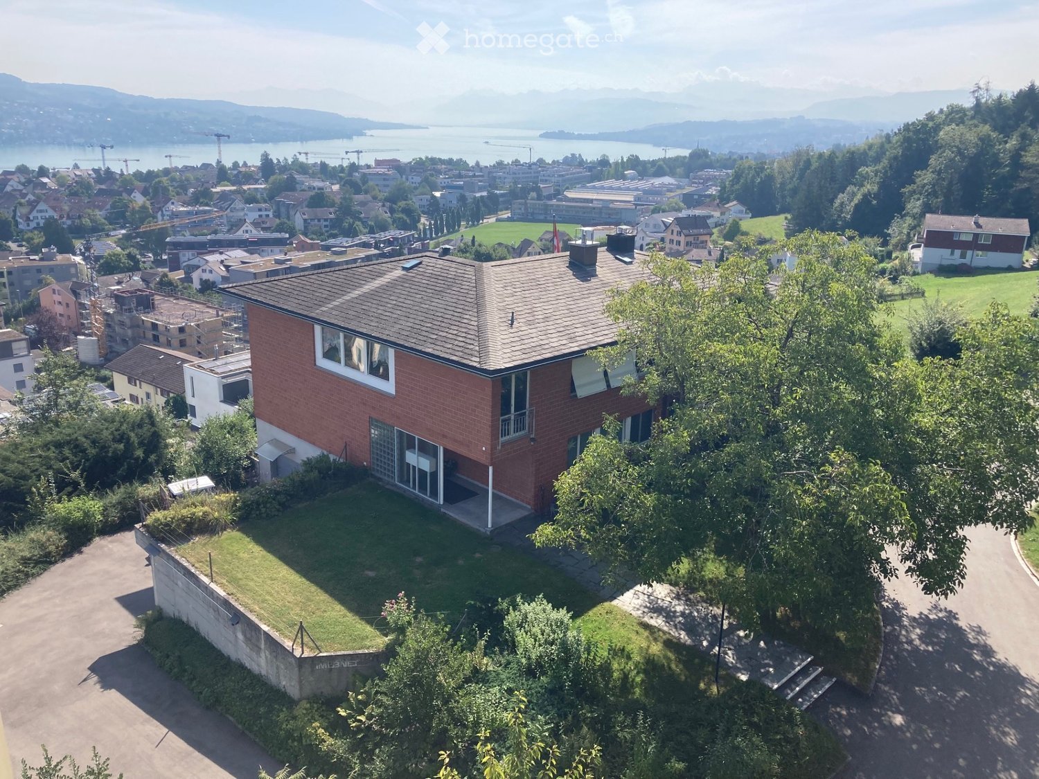 2 story house, red brick, white windows, large windows, garden, trees, lake view