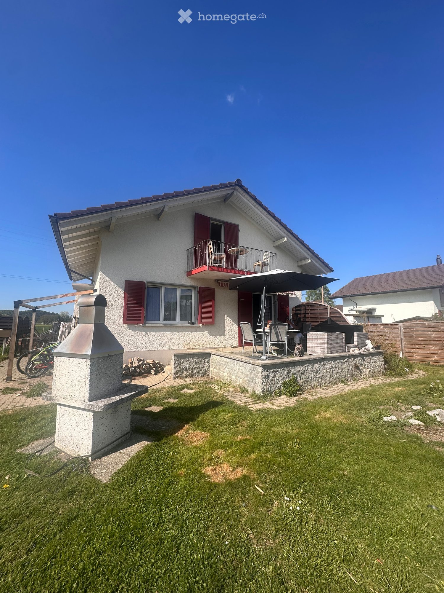 2 story house, white exterior, red shutters, balcony, outdoor seating, fireplace, garden