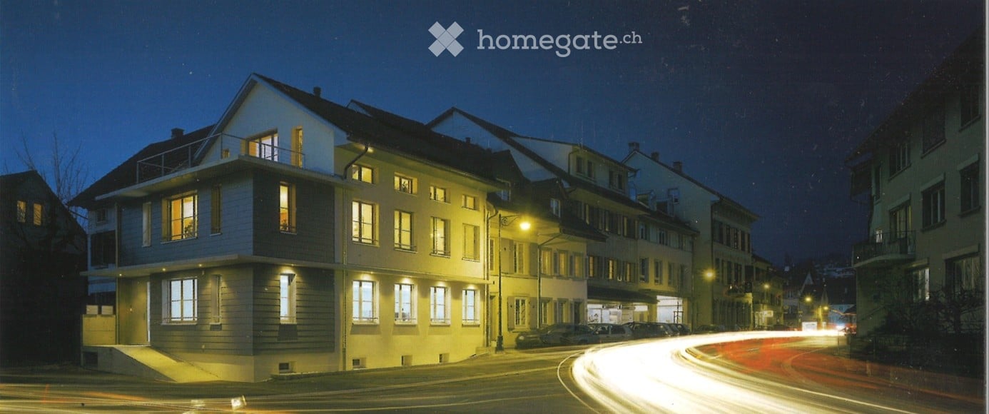 3 story house, white exterior, multiple windows, balcony, street lights, cars parked