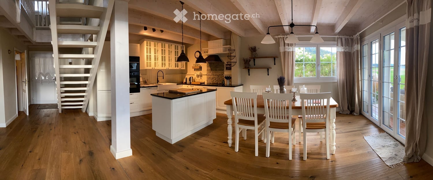 white kitchen, large table, hardwood floors, stairs