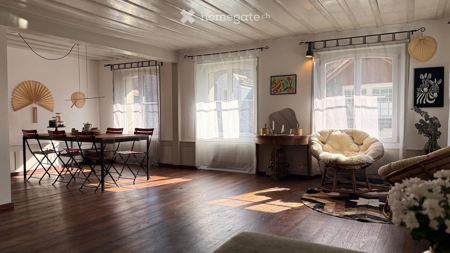 wooden floor, dining table with chairs, round chair, round table, white walls, large windows, curtains, artwork, rug, plants
