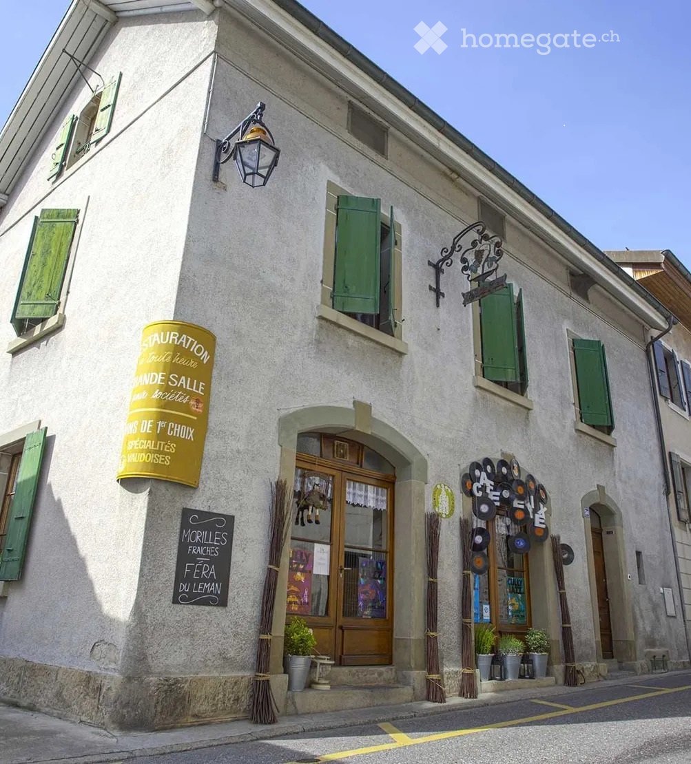 3 story building, white walls, green shutters, lamp, sign, plants, wooden door, glass door
