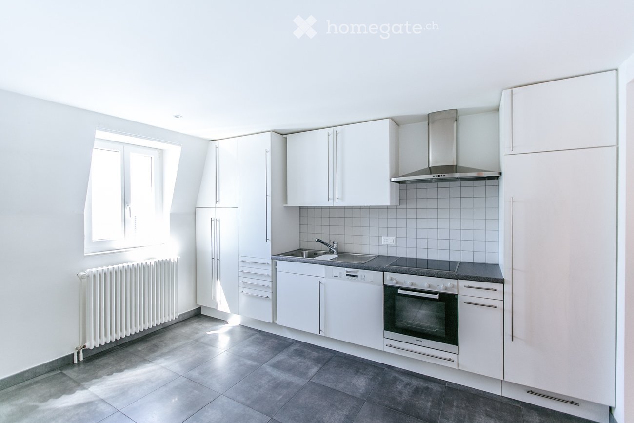 modern kitchen with white cabinets, tiled floor, stainless steel appliances, window, radiator