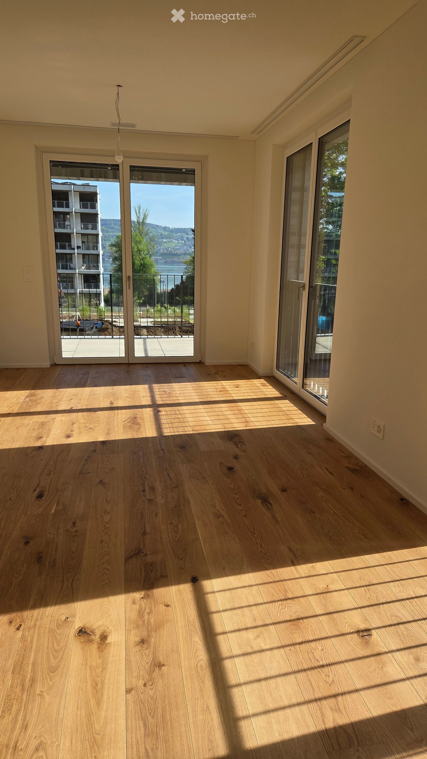large room, wooden floor, sliding glass doors, balcony, view of the outside