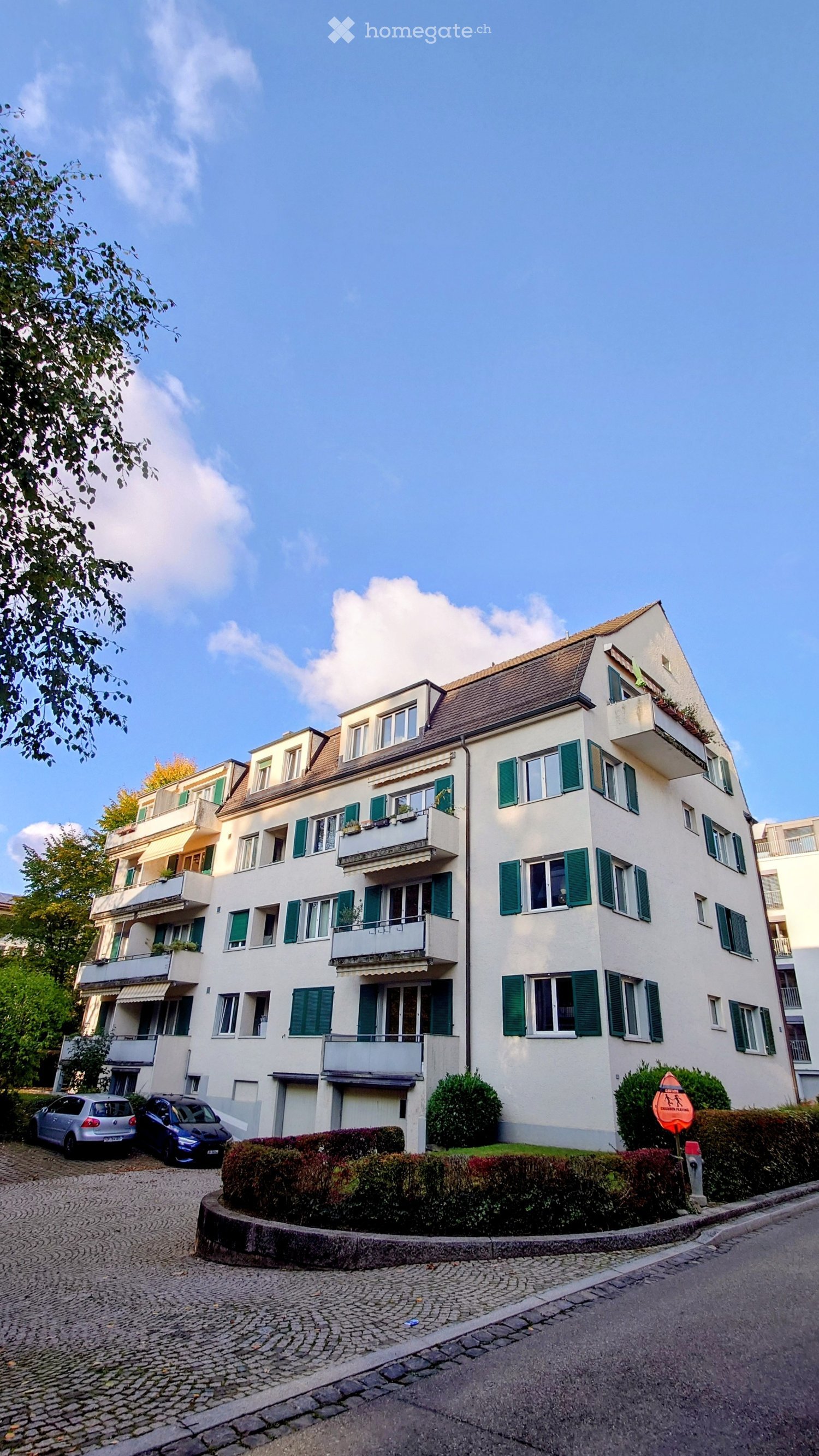 multi-family house, white walls, green shutters, balconies, brick roof