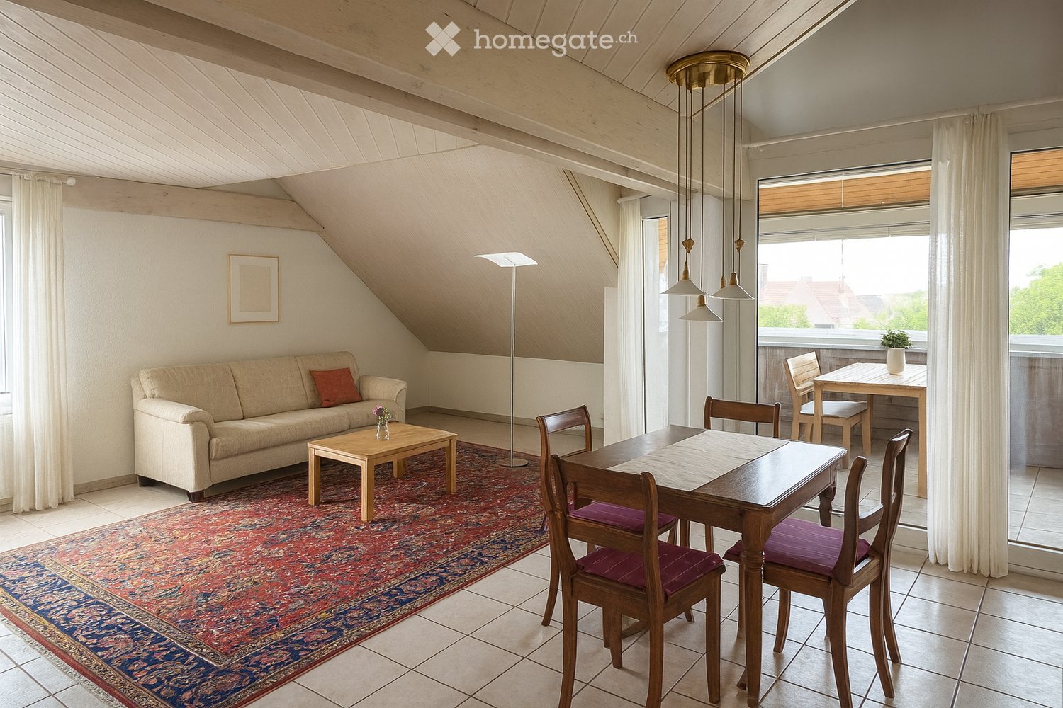 A furnished room with a couch, coffee table, rug, dining table, chairs, lamp, plant, and picture frame.