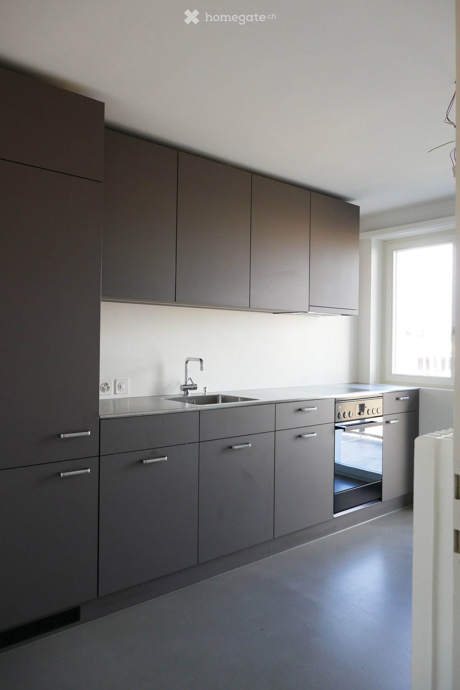 modern design, dark gray cabinets, stainless steel appliances, large window