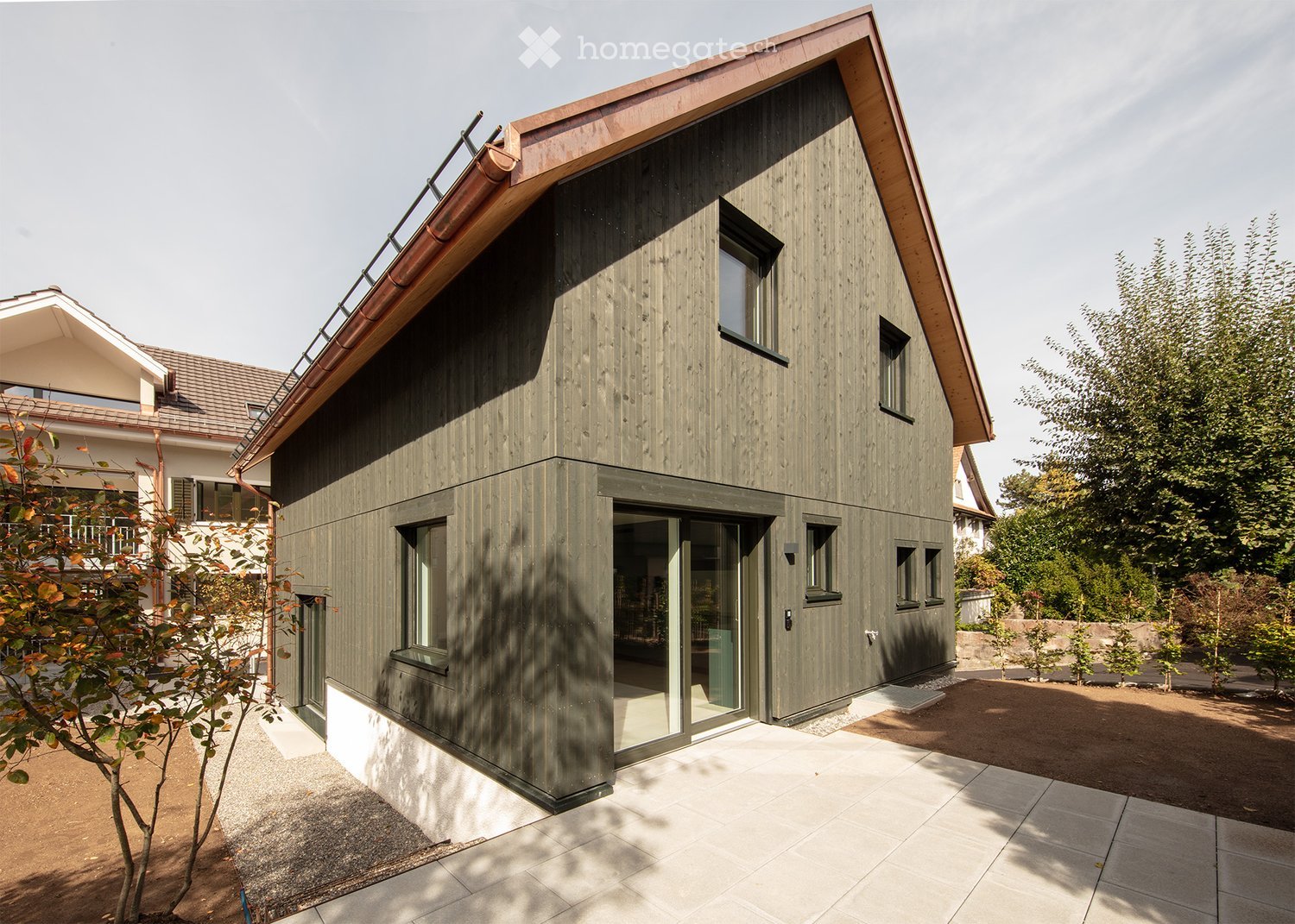 modern house, green exterior, glass doors, windows, copper roof, driveway, trees