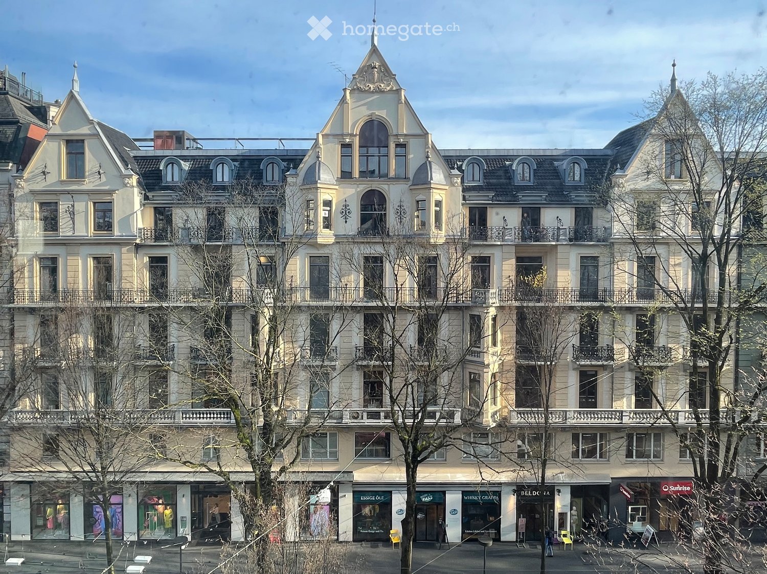 Large residential building with multiple stories, balconies, and decorative elements.