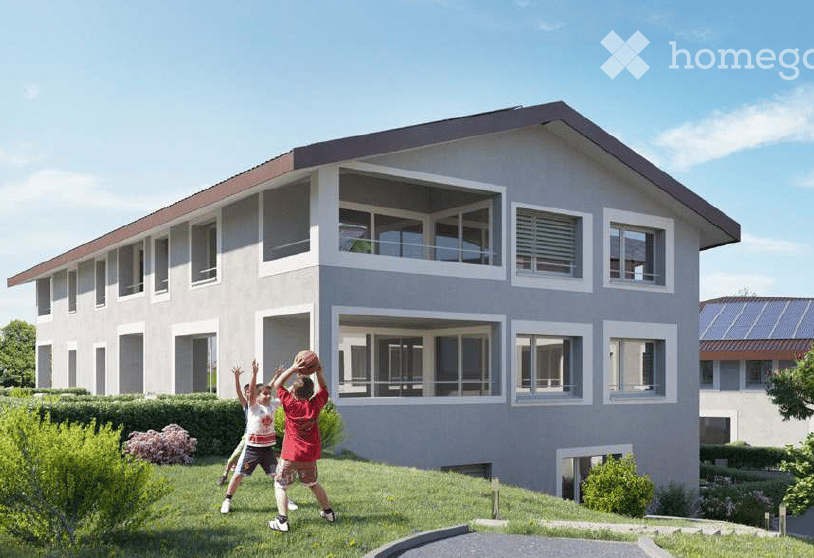 House. Modern two-story house with large windows and a balcony, surrounded by a well-maintained garden.