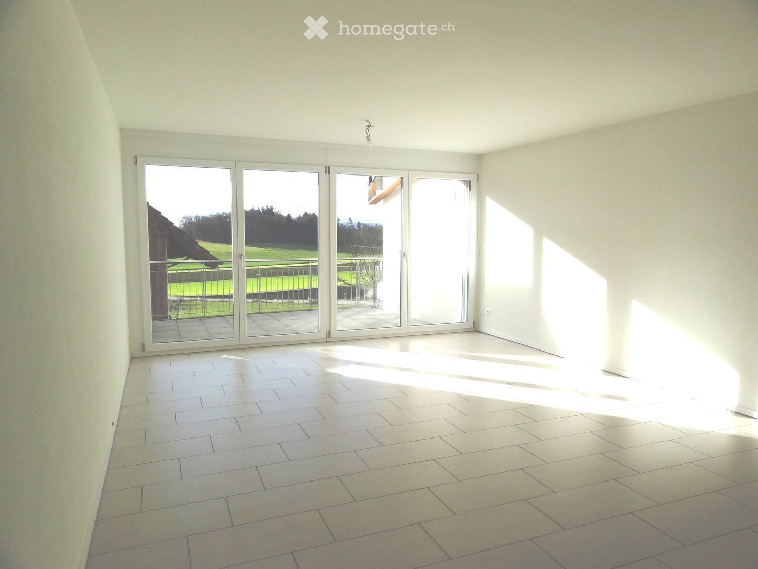 empty room, white walls, white tiles, large sliding glass doors, balcony, view of a field