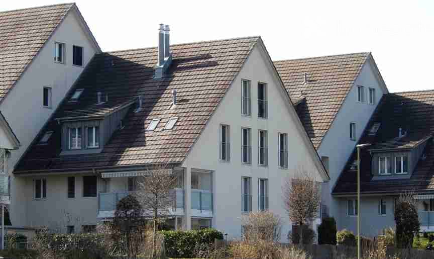 row of 4 houses, brown roof, white walls, multiple windows, balconies