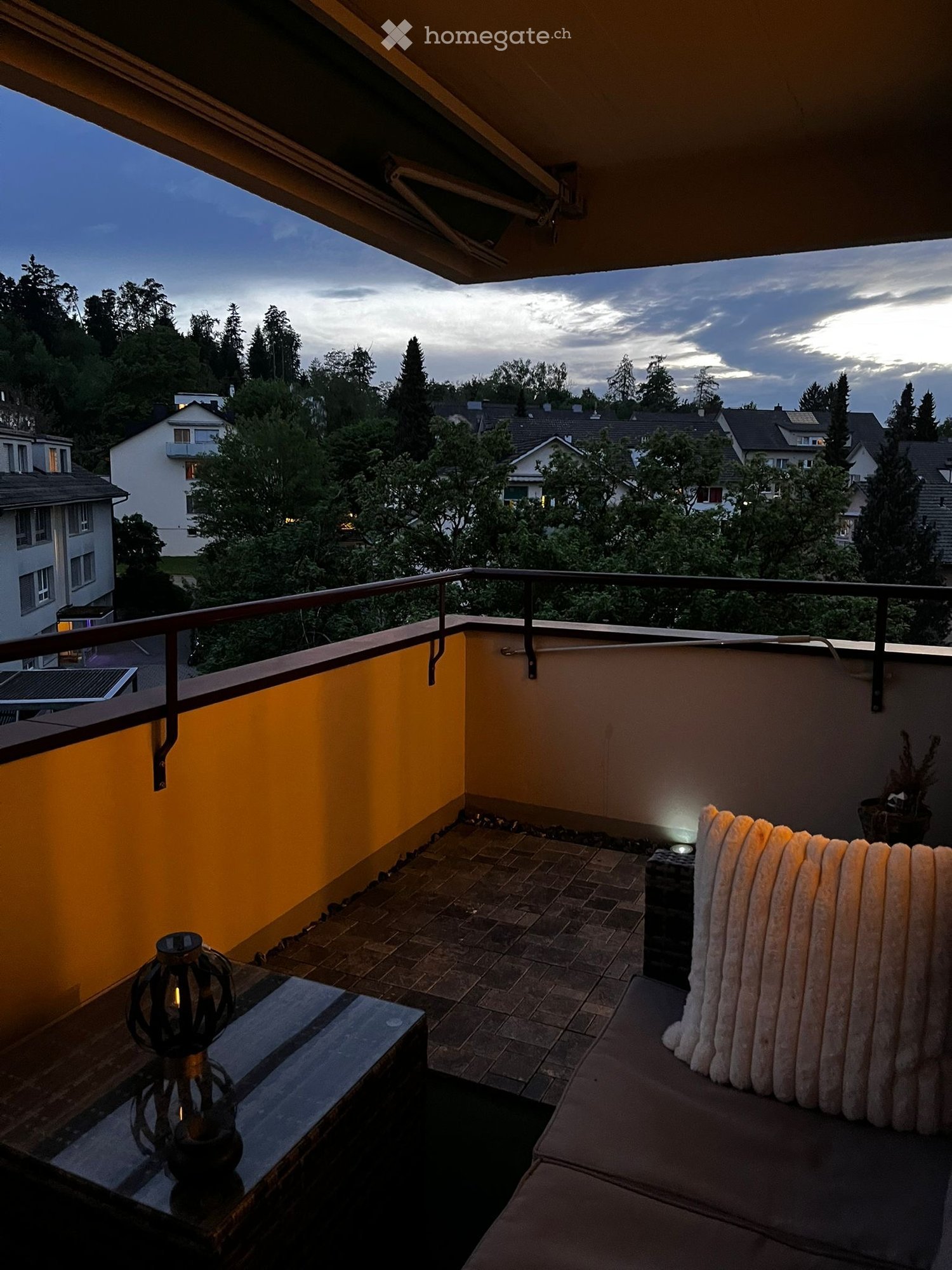 Balcony / Terrace. Balcony with a view of the neighborhood, featuring a sofa, a small table with a lamp, and a potted plant.