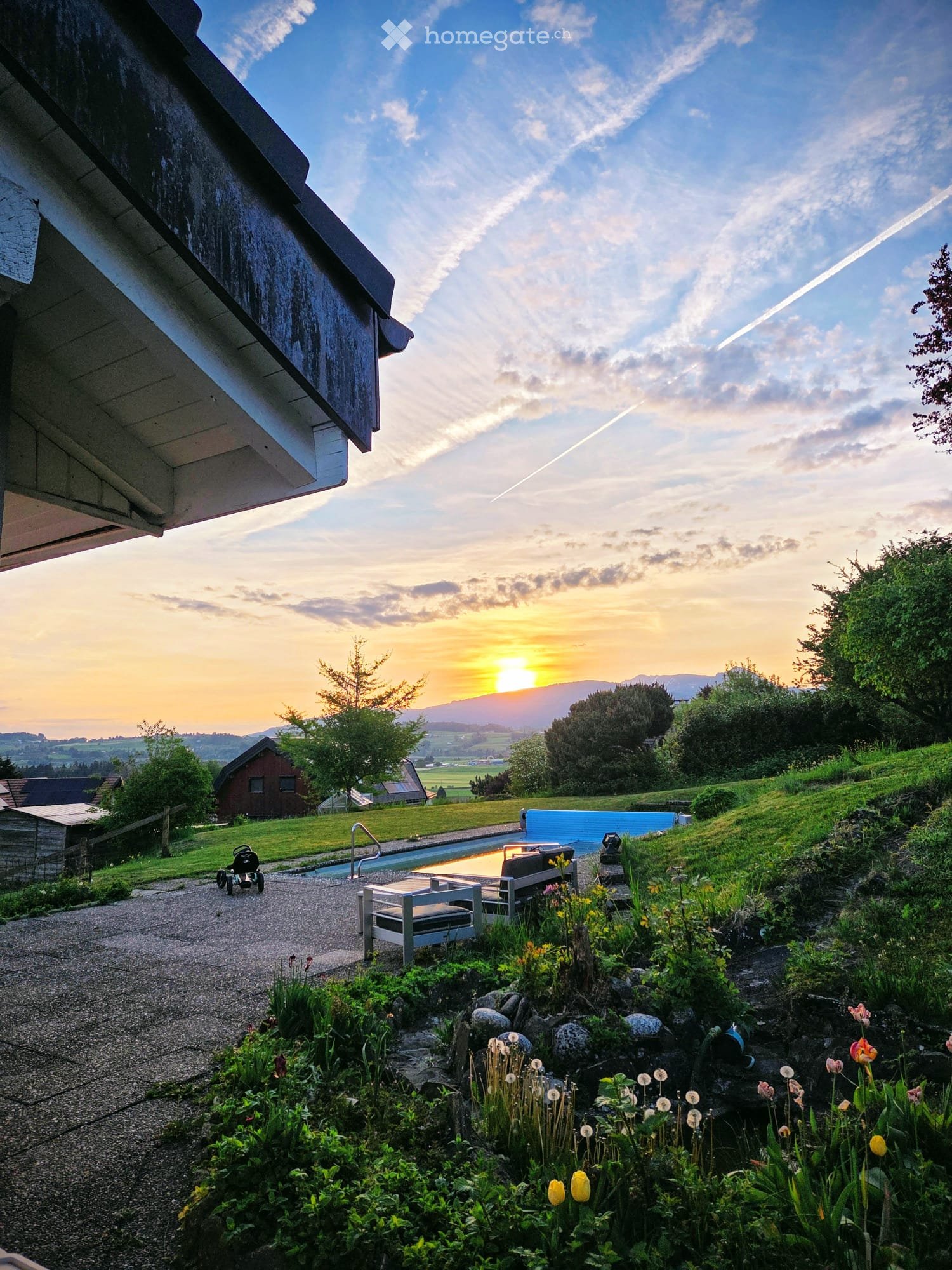 Garden / Outdoor Area. Garden with a swimming pool, patio furniture, and a view of the sunset over a valley.