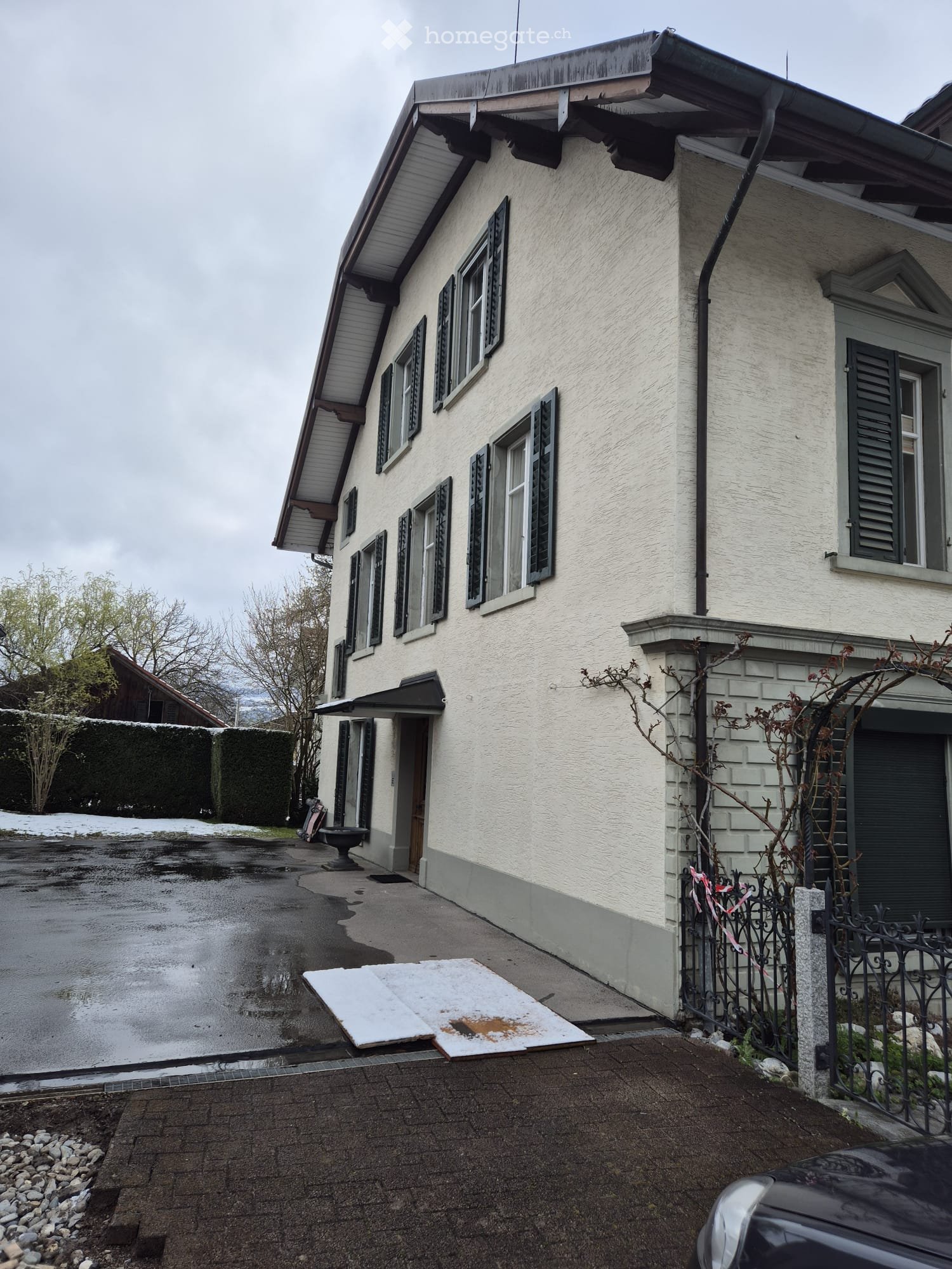2 story house, white exterior, multiple windows, driveway, black awning, black fence
