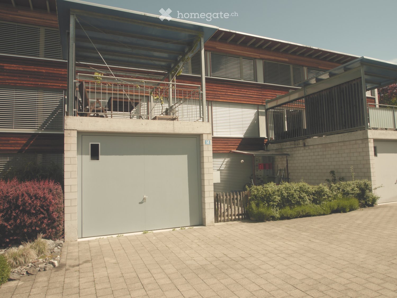 House. Modern two-story house with a garage, balconies, and a paved driveway.