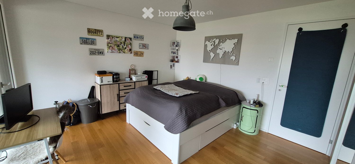 room with desk, bed, monitor, printer, trash can, small rug