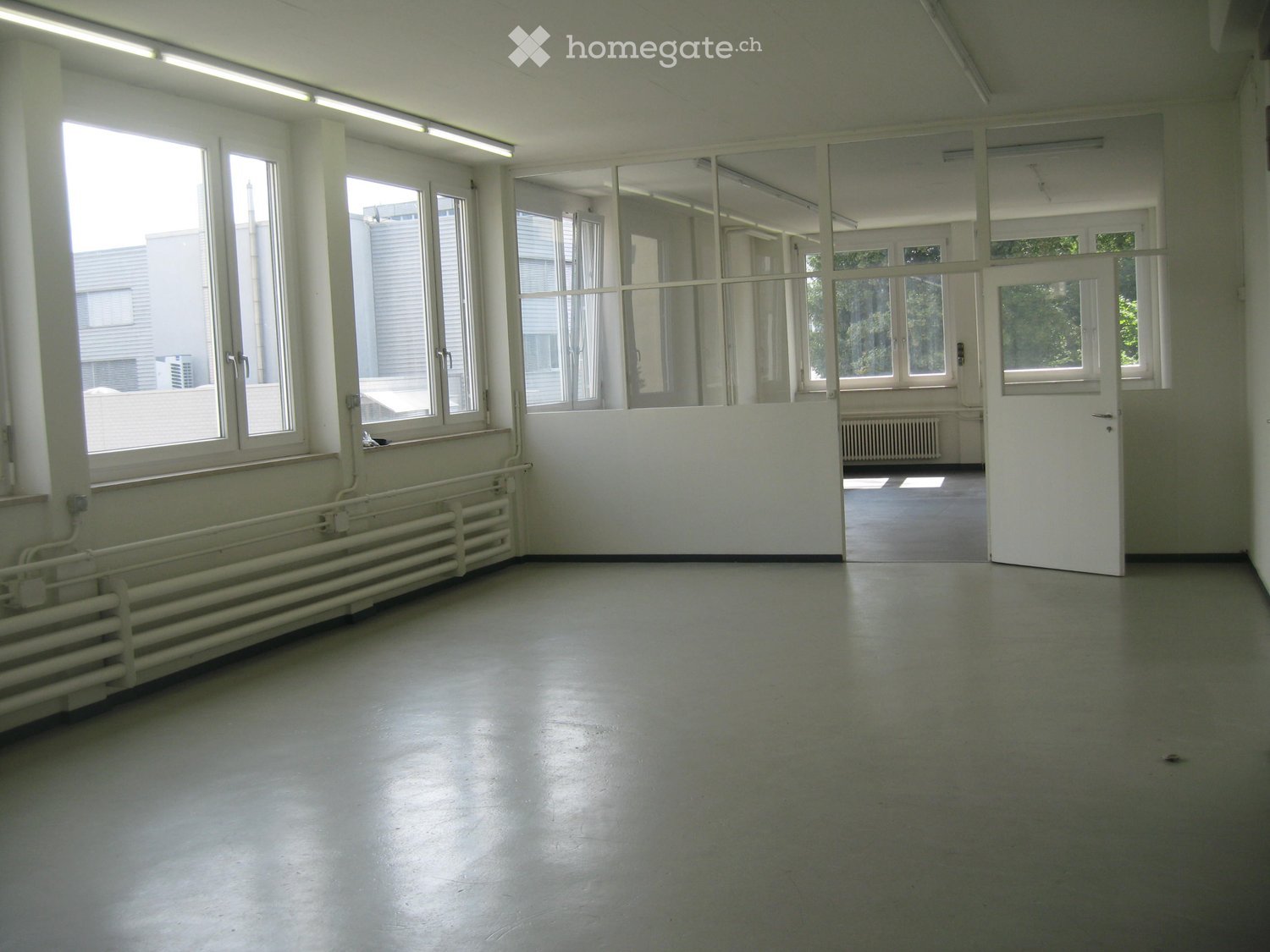 Unfurnished Room. Empty room with large windows, white walls, and a polished concrete floor. No furniture or equipment is present.