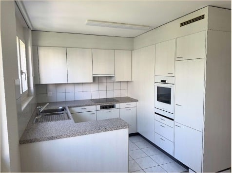 Kitchen. Modern kitchen with white cabinets, granite countertop, stainless steel sink, and built-in oven.