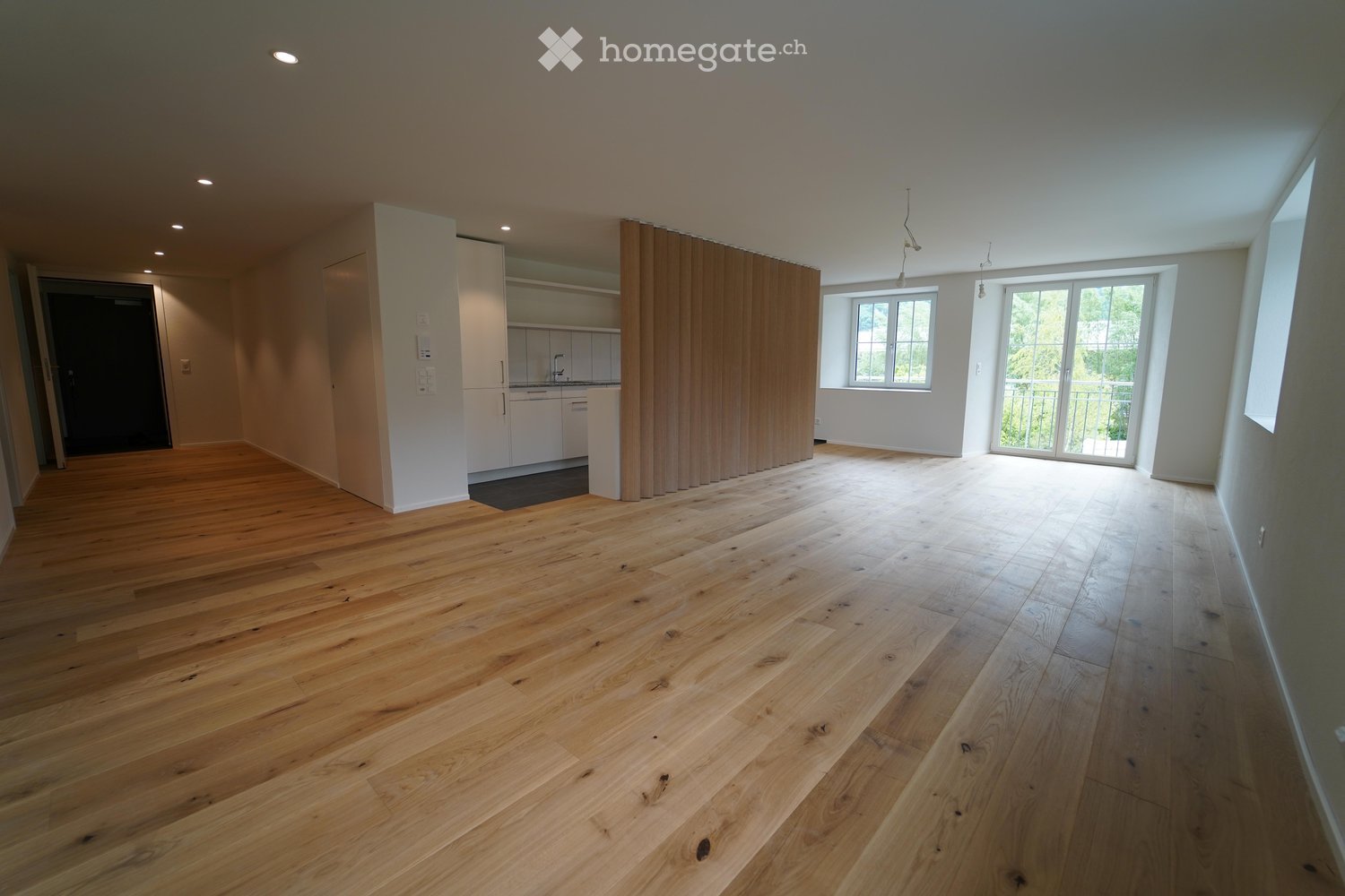 Unfurnished Room. Empty room with wooden flooring, white walls, large windows, and a sliding glass door leading to a balcony. The room is unfurnished with no visible furniture or equipment.