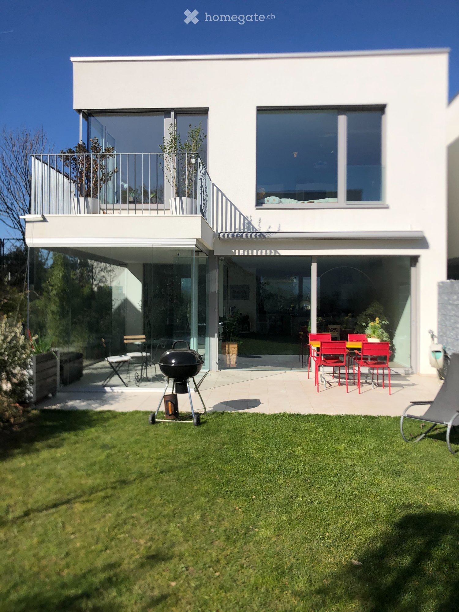 Garden / Outdoor Area. Modern house with a spacious garden, barbecue, outdoor seating, and a balcony with railings.