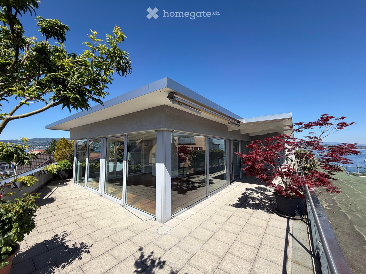 Balcony / Terrace. Modern terrace with sliding glass doors, metal railing, and potted plants. View of the sea and mountains.