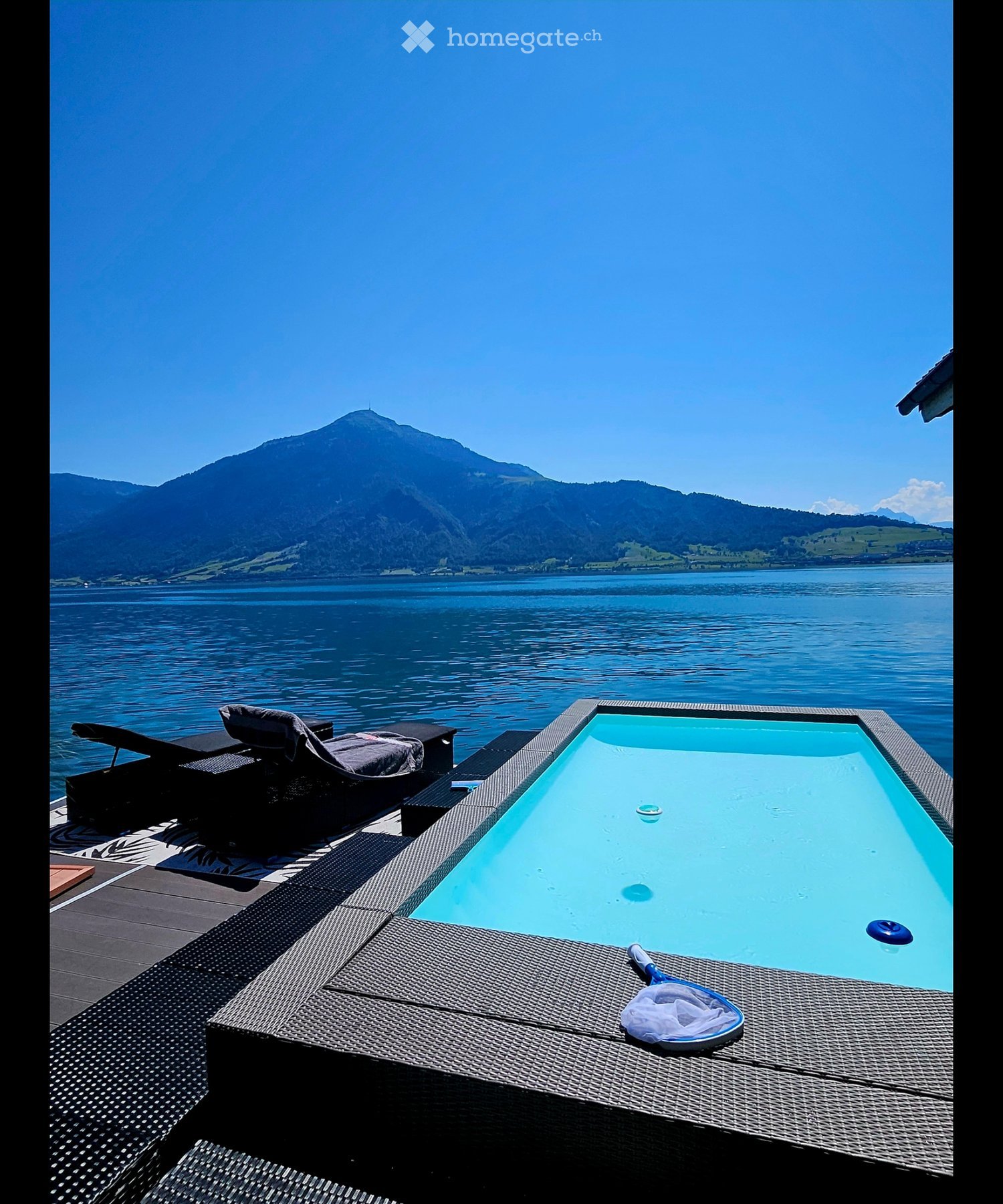 Garden / Outdoor Area. Private outdoor area with a swimming pool, lounge chairs, and a scenic view of a lake and mountains.
