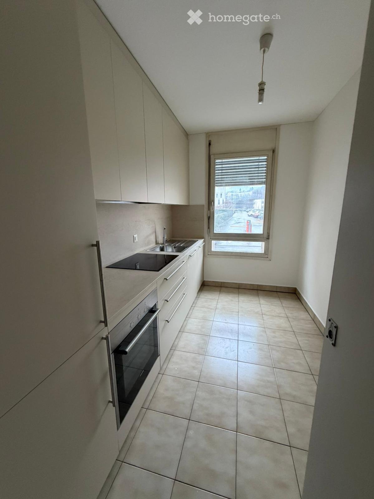 empty kitchen, white cabinetry, black counter, double sink, oven